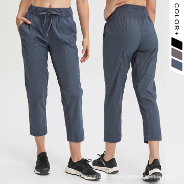 Nuevos pantalones de yoga Pantalones de mujeres con cordón con cordón y bolsillos Mujeres Pantalones deportivos Capri tejido febric febric pantalones de chándal esenciales